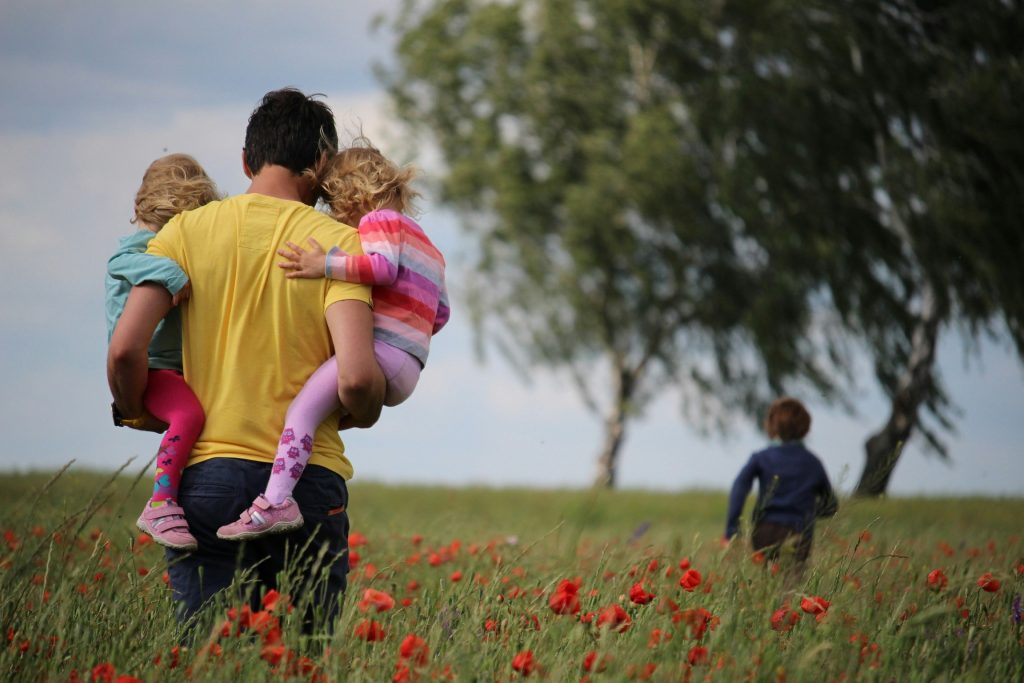 Father with children on a walk in a field